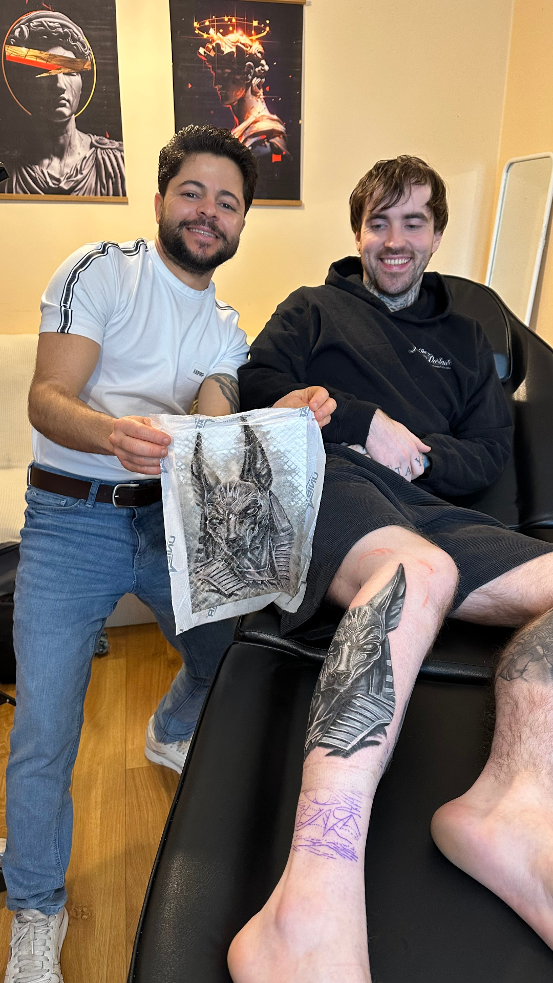 Fernando Pinheiro with a client after finishing an Anubis leg tattoo