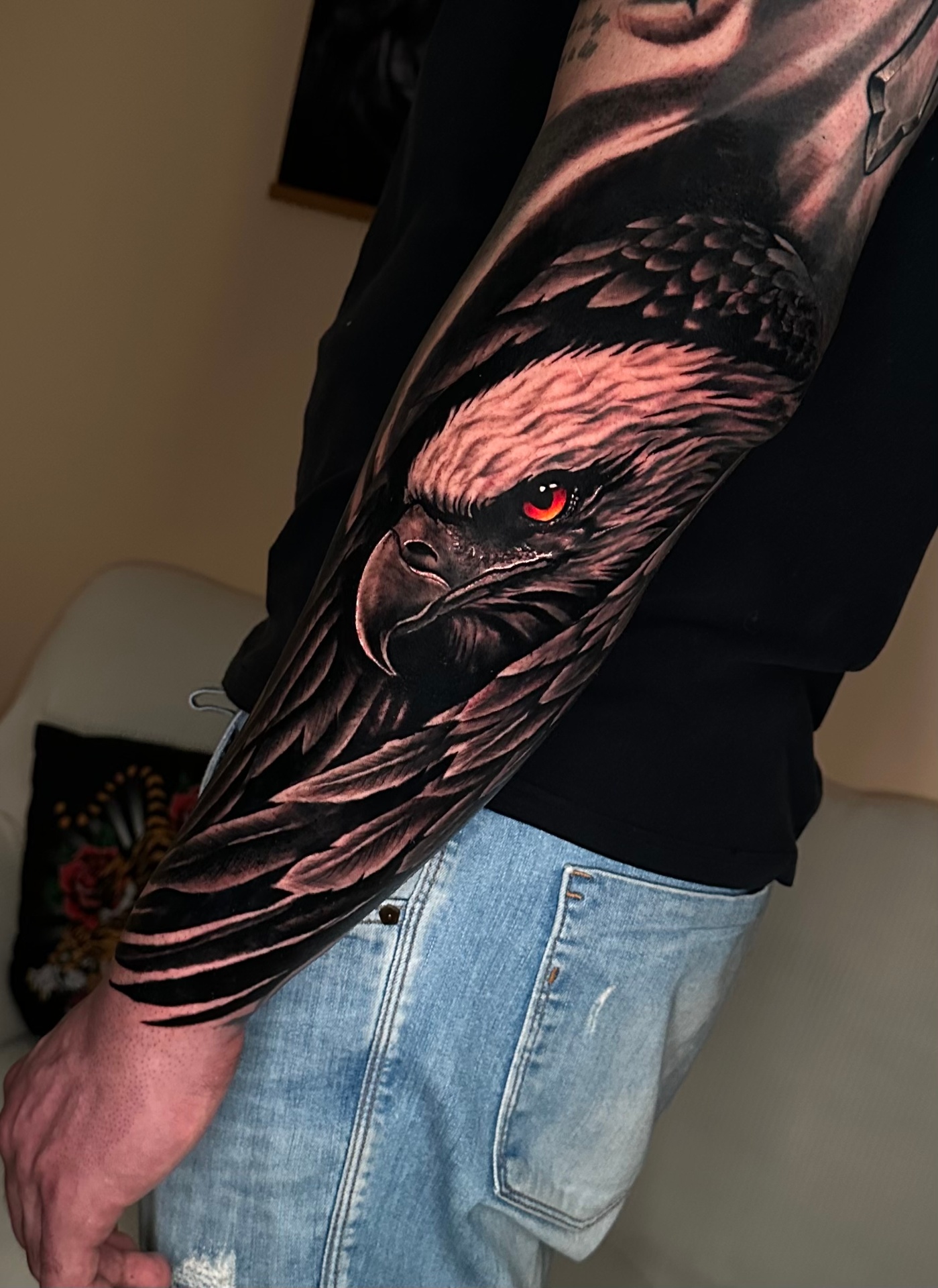 Photorealistic eagle forearm tattoo with red eye detail
